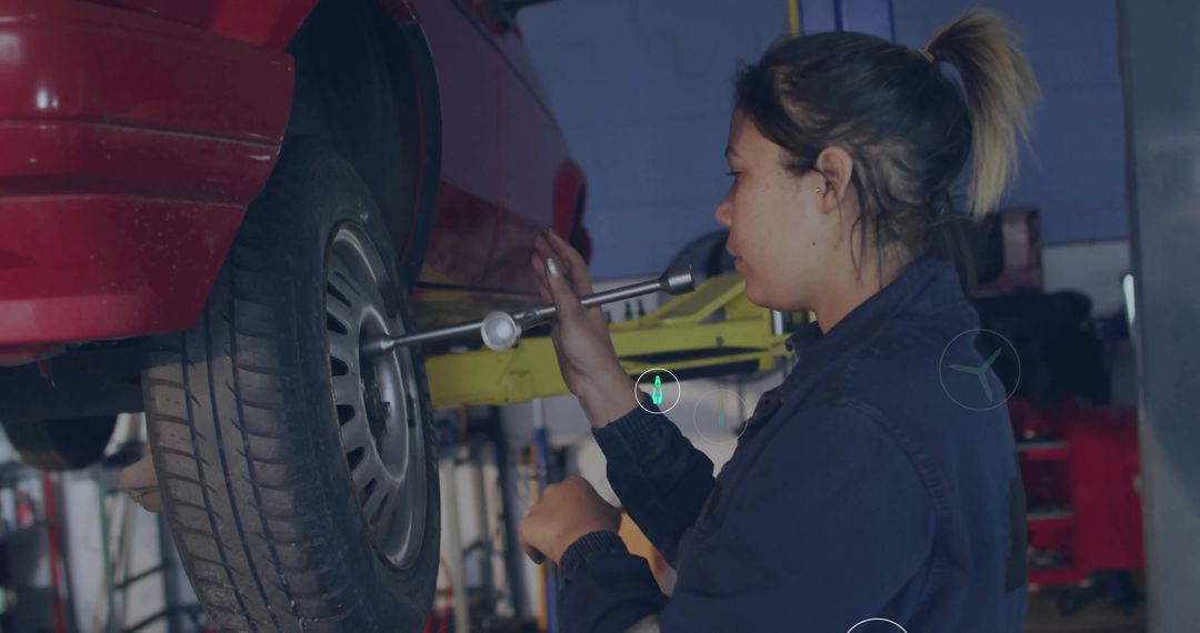 Woman Mechanic Using Torque Wrench on Car Wheel in Workshop