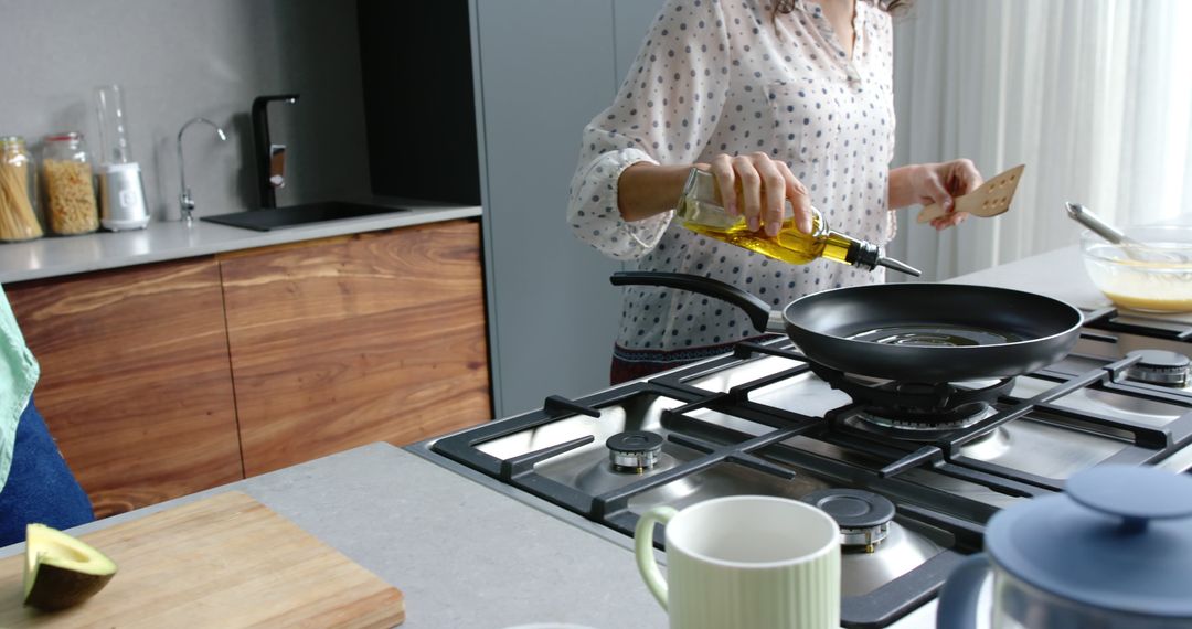 Home Cooking in Modern Kitchen: Woman Pouring Olive Oil into Pan - Free Images, Stock Photos and Pictures on Pikwizard.com