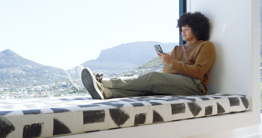 Relaxed Young Man Browsing on Smartphone Overlooking Urban View