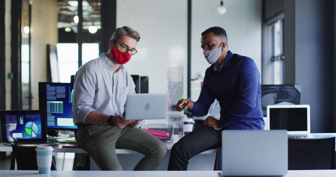 Diverse Business Colleagues Discussing Work with Laptops in Modern Office