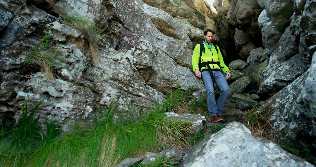 Hiker in green jacket descending rocky mountain trail - Free Images, Stock Photos and Pictures on Pikwizard.com