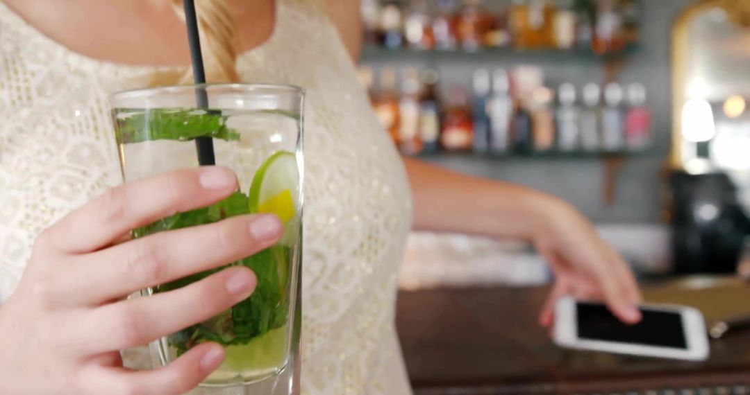 Elegant Woman Enjoying a Refreshing Cocktail at Stylish Bar