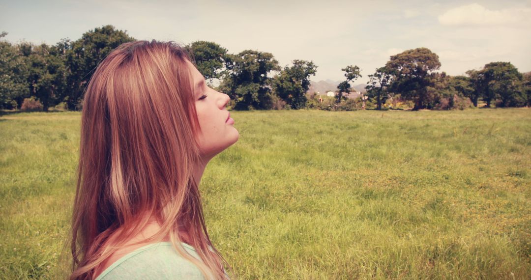 Serene Young Woman Enjoying Outdoors in Lush Green Field - Free Images, Stock Photos and Pictures on Pikwizard.com