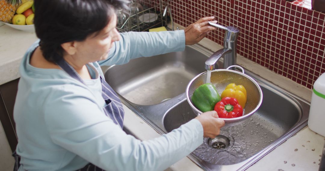 Woman Washing Colorful Bell Peppers in Kitchen Sink - Free Images, Stock Photos and Pictures on Pikwizard.com