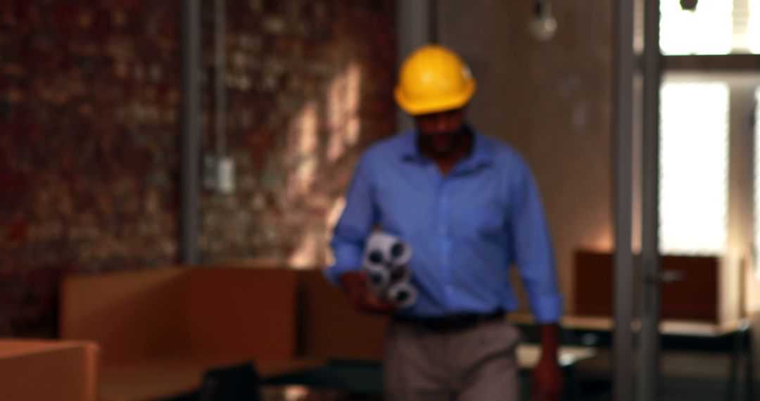 Architect Wearing Hard Hat Holding Blueprints in Office - Free Images, Stock Photos and Pictures on Pikwizard.com