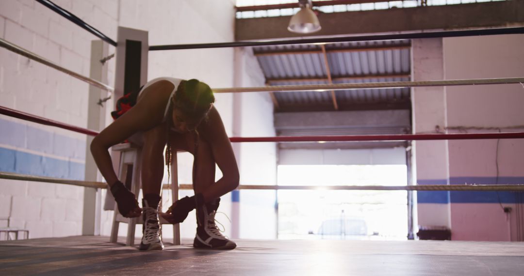 Female Boxer Tying Shoes in Gym Boxing Ring - Free Images, Stock Photos and Pictures on Pikwizard.com