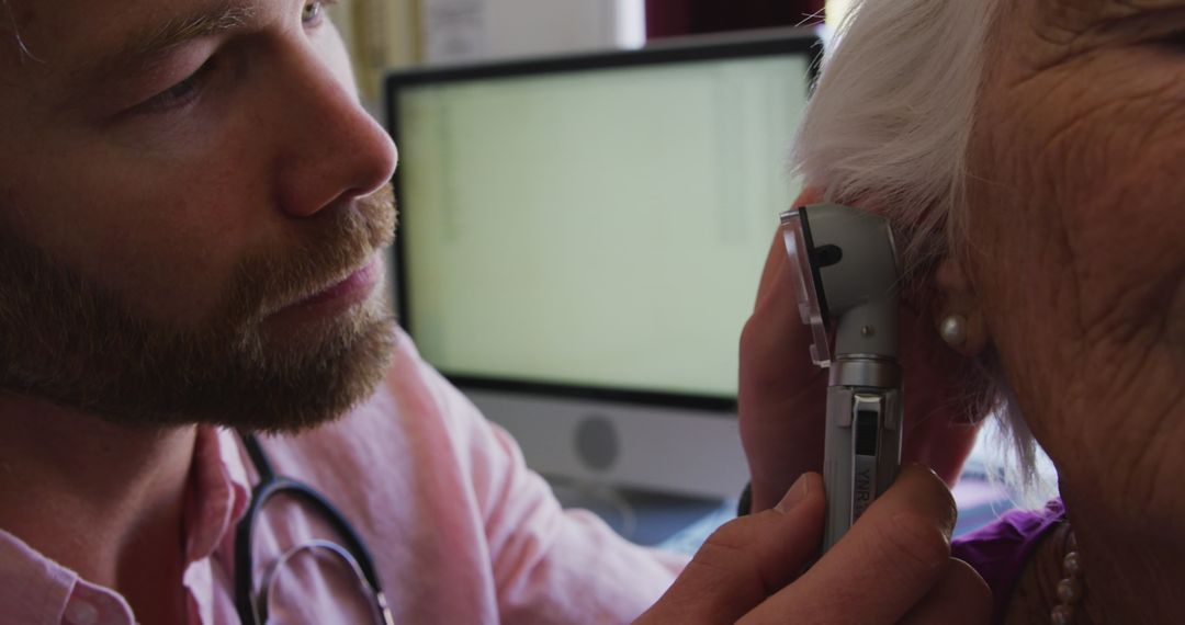 Doctor Conducts Ear Examination with Otoscope on Elderly Woman