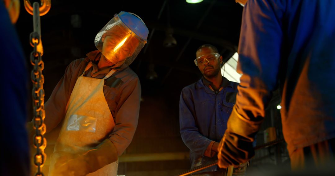 Industrial Workers in a Metal Workshop Wearing Protective Gear - Free Images, Stock Photos and Pictures on Pikwizard.com