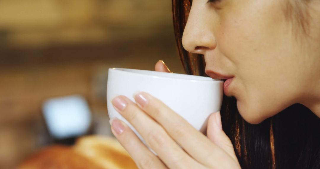 Woman Drinking Hot Beverage from White Cup Indoors - Free Images, Stock Photos and Pictures on Pikwizard.com