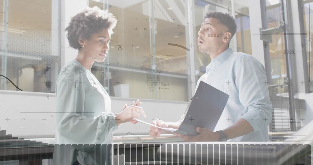Colleagues Collaborating in Modern Office Atrium with Data Overlay