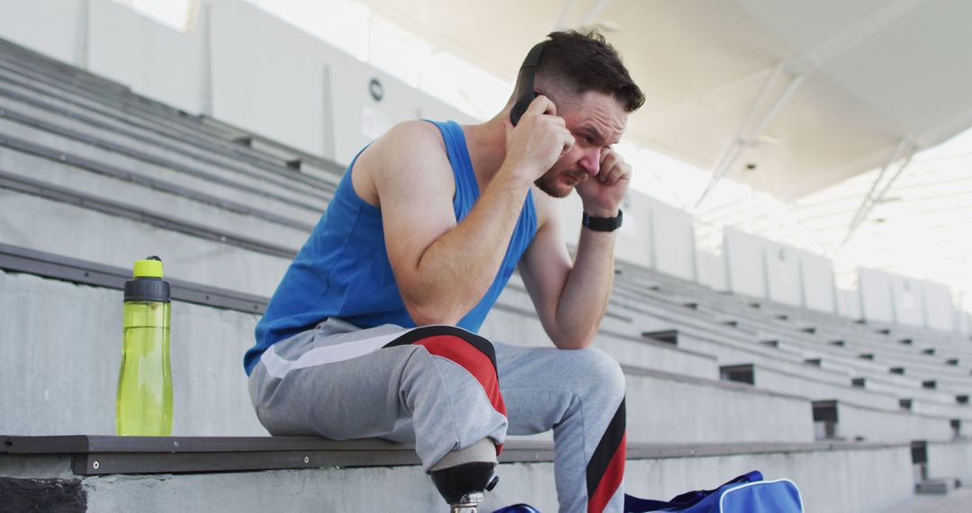 Athletic Man with Prosthetic Leg Talking on Phone in Stadium - Free Images, Stock Photos and Pictures on Pikwizard.com