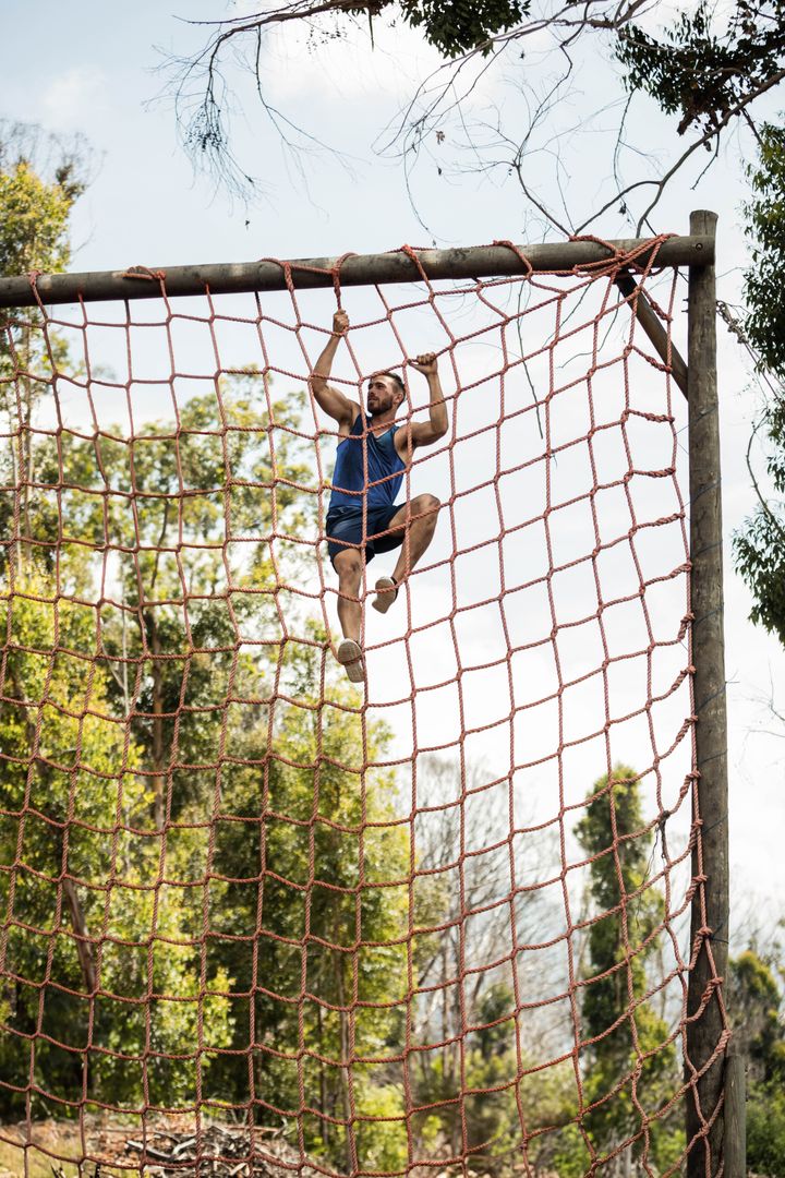 Man Climbing Cargo Net in Outdoor Obstacle Training