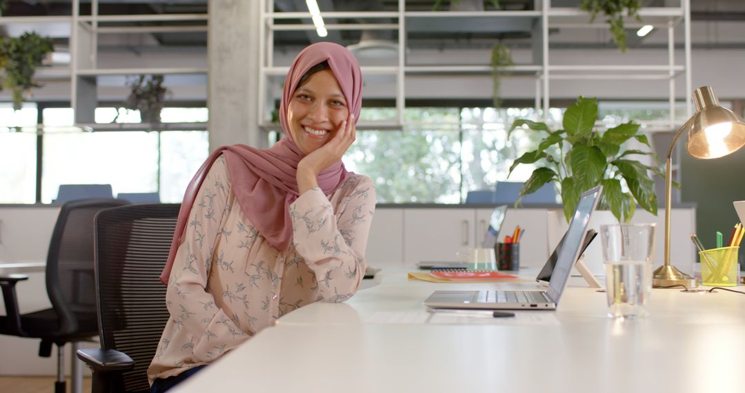 Smiling Businesswoman in Hijab Working in Modern Office - Free Images, Stock Photos and Pictures on Pikwizard.com