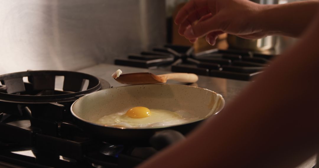 Person Cooking Egg in Skillet on Gas Stove - Free Images, Stock Photos and Pictures on Pikwizard.com