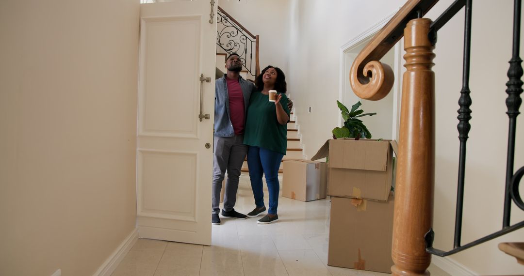 Couple Moving into New Home with Cardboard Boxes and Joyful Expressions