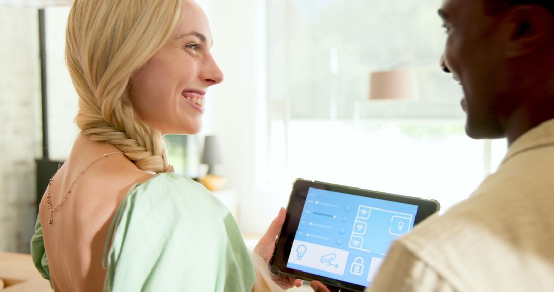Couple Using Tablet for Smart Home Control in Modern Living Room