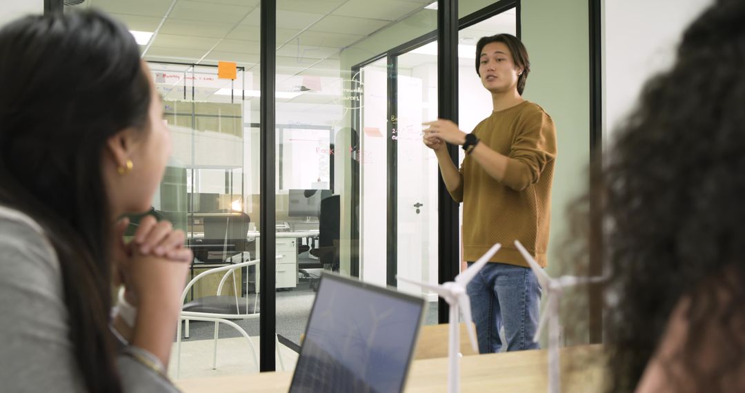 Diverse Team Collaborating in Office Meeting with Wind Turbine Model