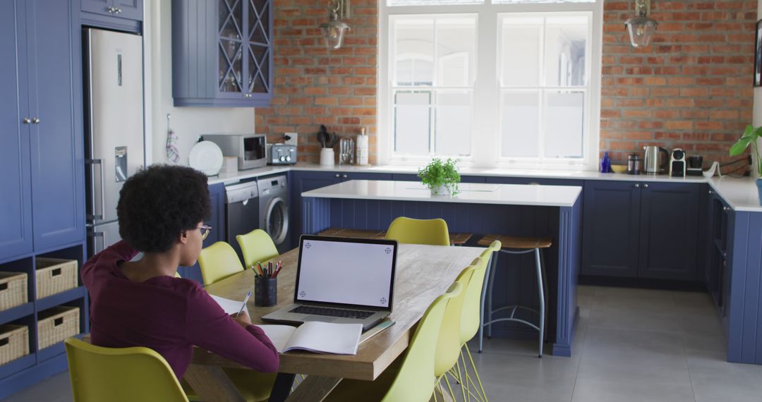 Remote Work in Modern Kitchen with Brick Wall and Blue Cabinets - Free Images, Stock Photos and Pictures on Pikwizard.com