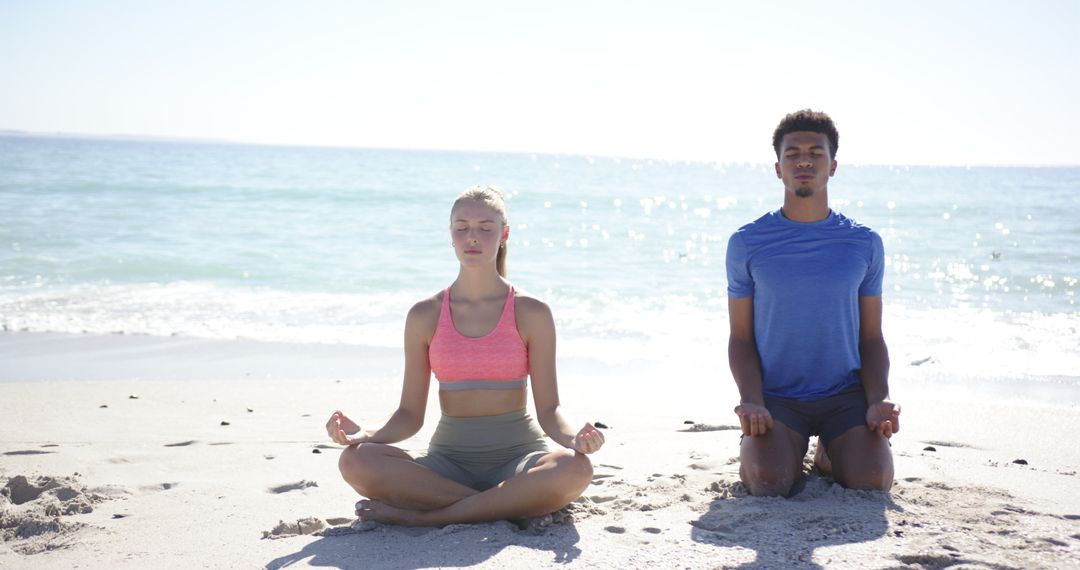 Diverse Couple Practicing Mindful Meditation on Beach
