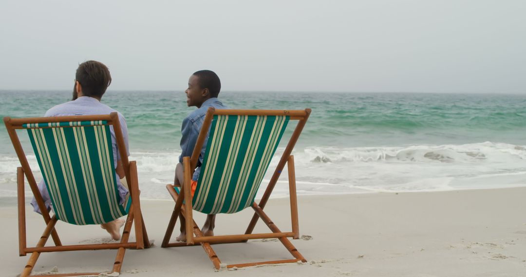 Relaxing at Beach While Chatting on Wooden Loungers