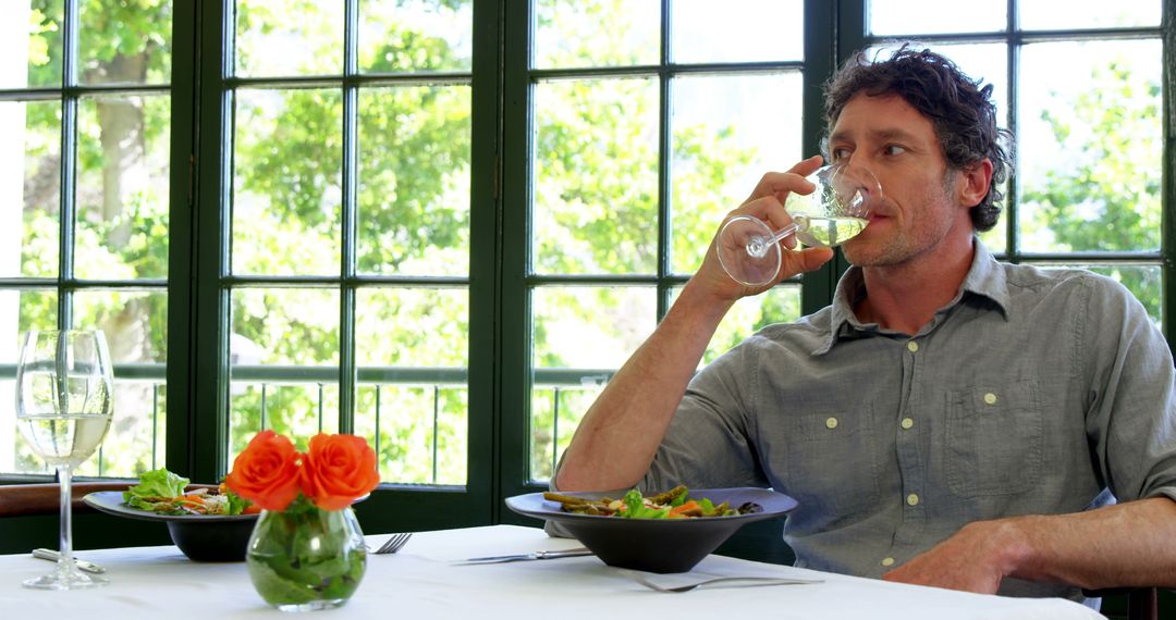 Man Enjoying Lunch and Wine in Bright Garden Restaurant - Free Images, Stock Photos and Pictures on Pikwizard.com