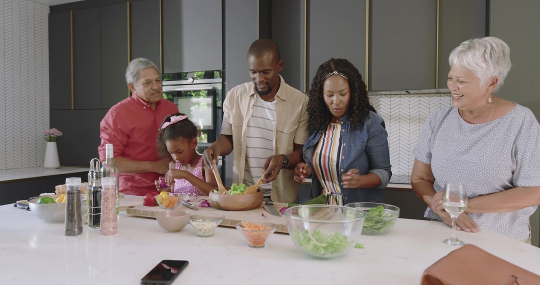 Multigenerational Family Preparing Fresh Salad Together on Modern Kitchen Island