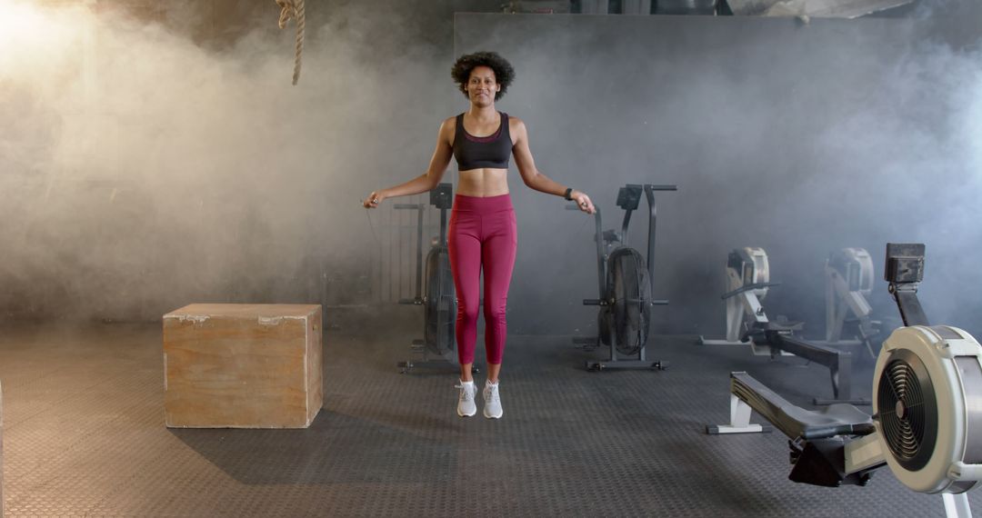 Smiling Woman Skipping Rope in Gym with Exercise Equipment - Free Images, Stock Photos and Pictures on Pikwizard.com