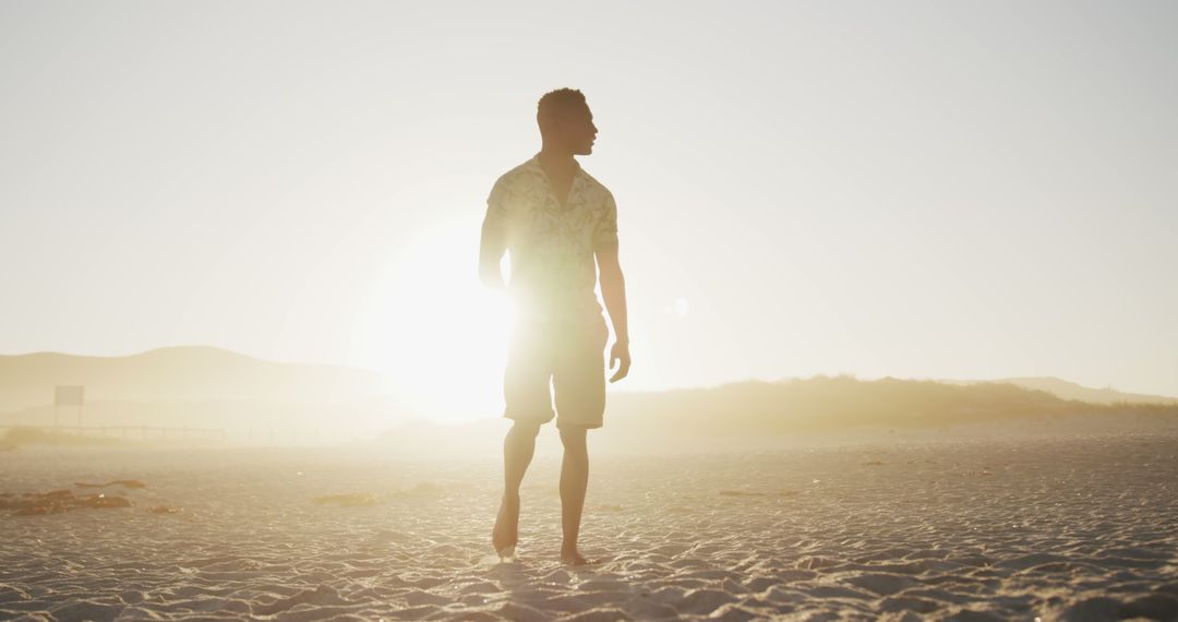 Man Walking on Sunlit Beach at Sunset - Free Images, Stock Photos and Pictures on Pikwizard.com