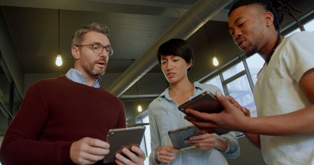 Diverse Team Collaborating on Tablets in Modern Office Environment