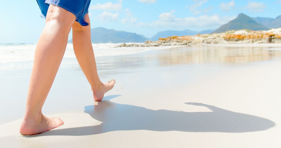 Barefoot Walk on Sunny Beach with Mountain View - Free Images, Stock Photos and Pictures on Pikwizard.com