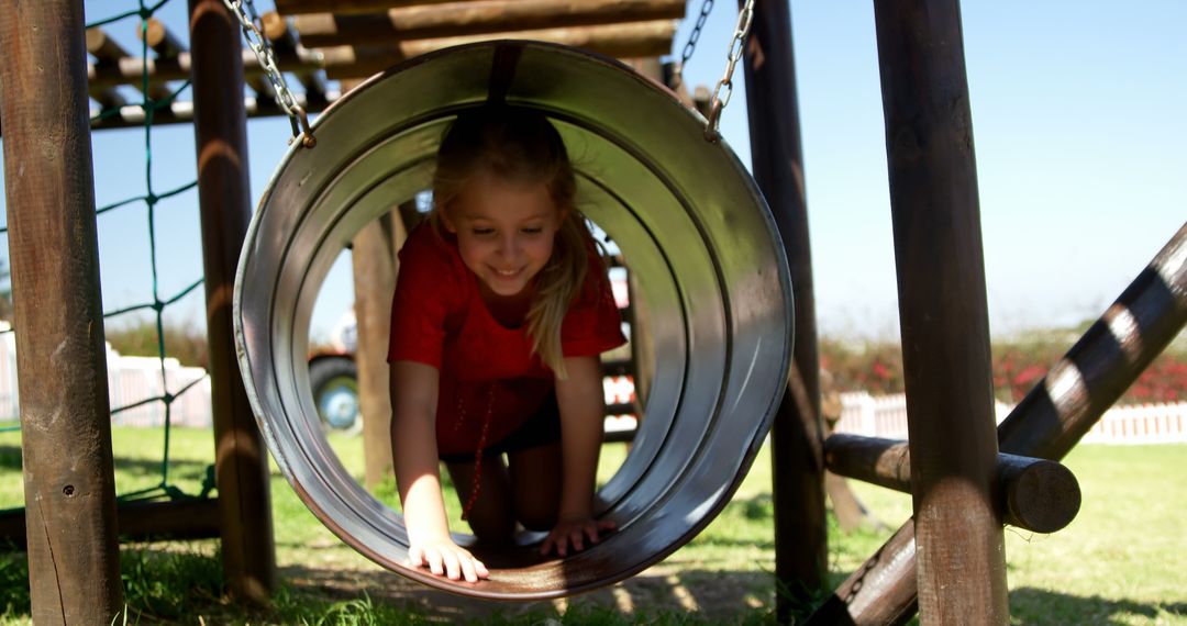 Happy Child Crawling Through Playground Tube - Free Images, Stock Photos and Pictures on Pikwizard.com