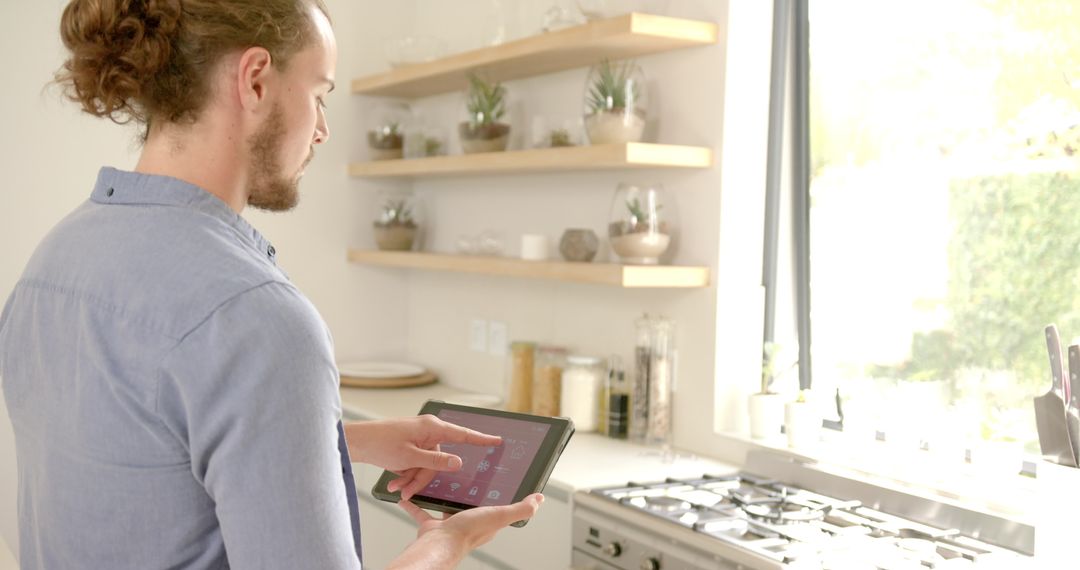 Young Man Using Smart Home App in Modern Kitchen