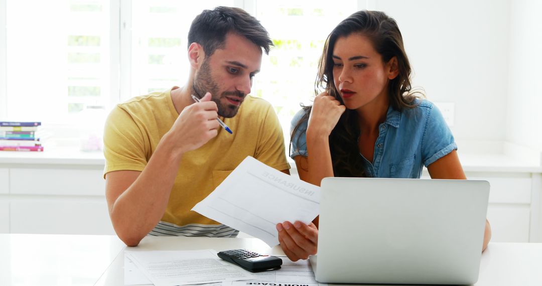 Couple Reviewing Financial Documents at Home, Laptop and Calculator on Table - Free Images, Stock Photos and Pictures on Pikwizard.com