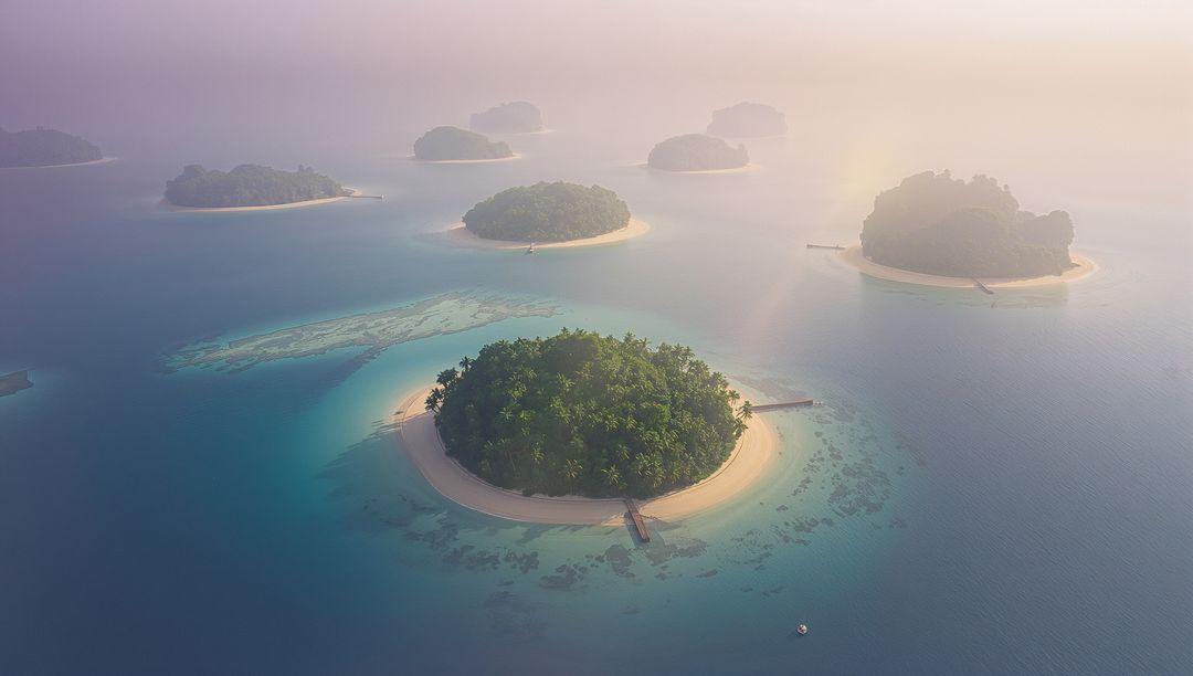 Serenity of Circular Islands in Morning Haze Over Turquoise Waters