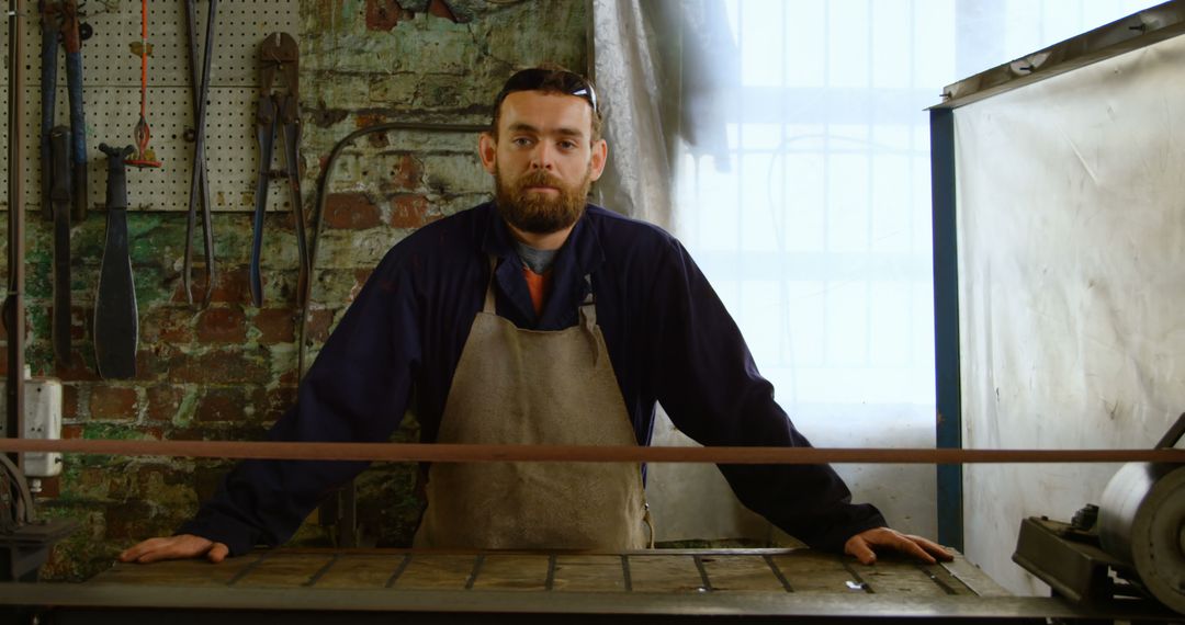 Bearded Craftsman in Apron Working in Industrial Workshop - Free Images, Stock Photos and Pictures on Pikwizard.com