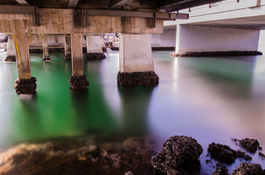 Tranquil Water Flow Under Bridge Supporting Structures