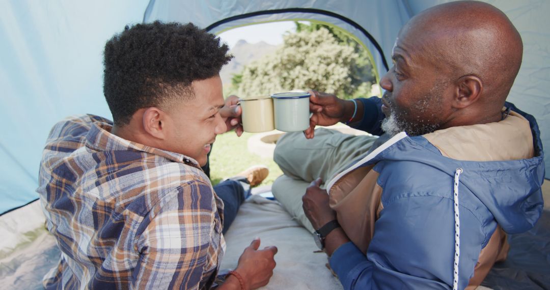 Father and Son Toast Inside Tent with Morning Coffee - Free Images, Stock Photos and Pictures on Pikwizard.com