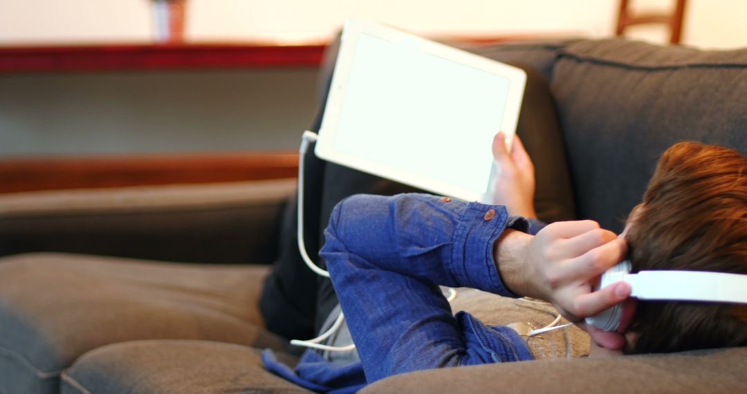 Relaxed Teen Listening to Music on Tablet - Free Images, Stock Photos and Pictures on Pikwizard.com