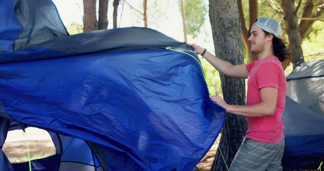 Young Man Setting Up Tent in Forest - Free Images, Stock Photos and Pictures on Pikwizard.com