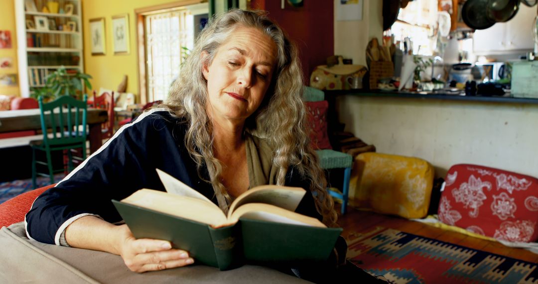 Senior Woman Reading Book in Cozy Home Interior - Free Images, Stock Photos and Pictures on Pikwizard.com