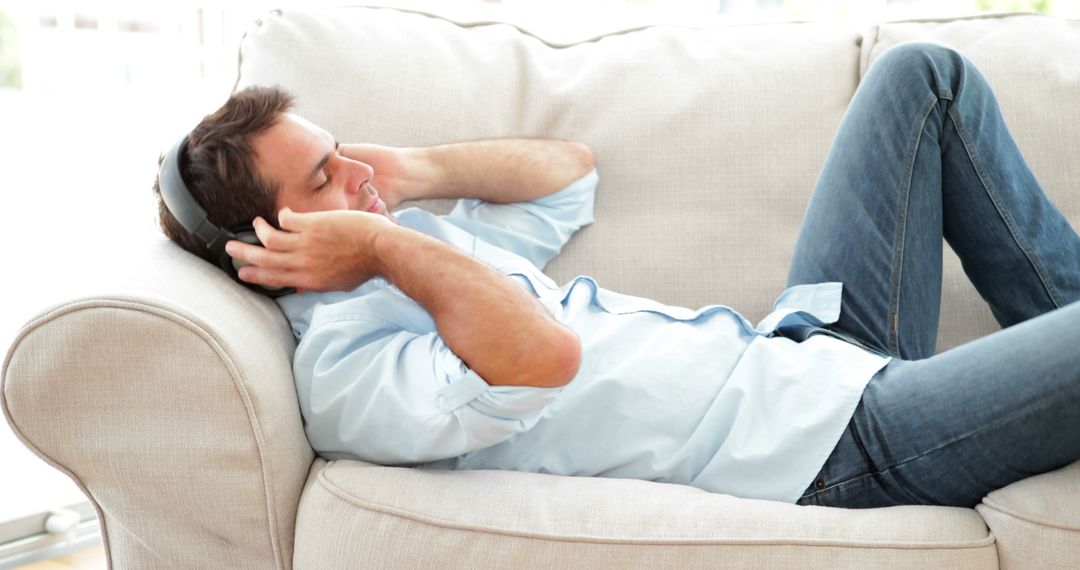 Man Relaxing on Couch with Headphones - Free Images, Stock Photos and Pictures on Pikwizard.com