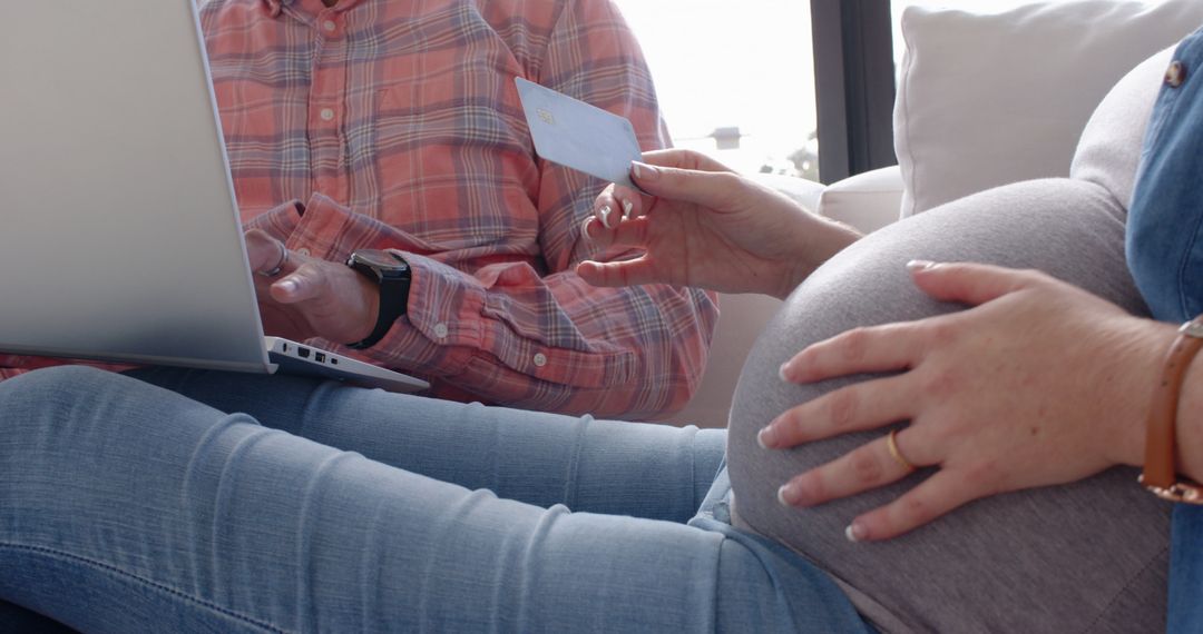 Pregnant Couple Online Shopping in Cozy Living Room Setting
