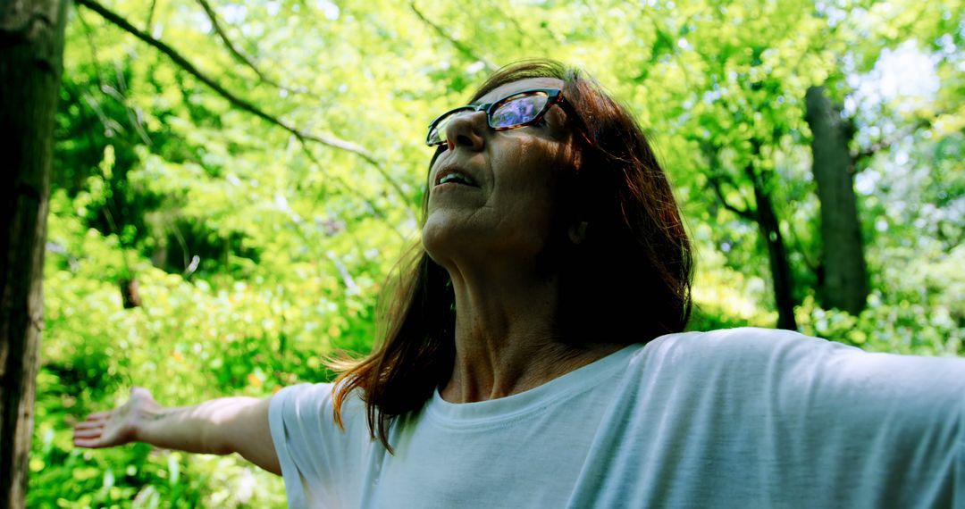 Woman Embracing Nature with Open Arms in Forest - Free Images, Stock Photos and Pictures on Pikwizard.com