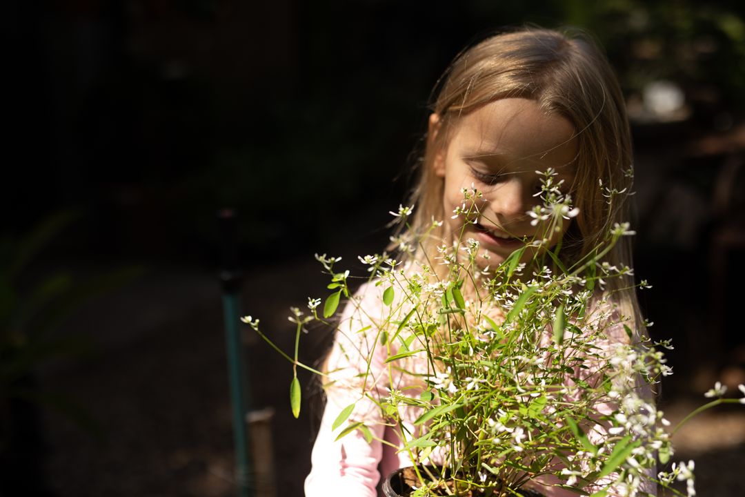 Young Girl Enjoying Gardening with Flowering Plant - Free Images, Stock Photos and Pictures on Pikwizard.com