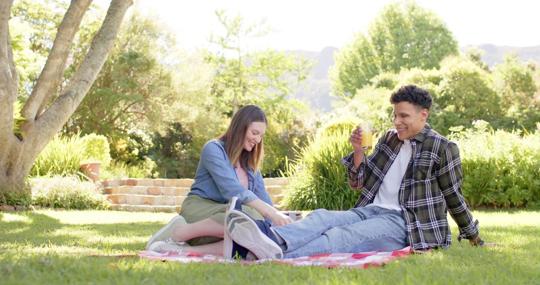 Happy Mid-20s Couple Enjoying Picnic in Sunny Garden