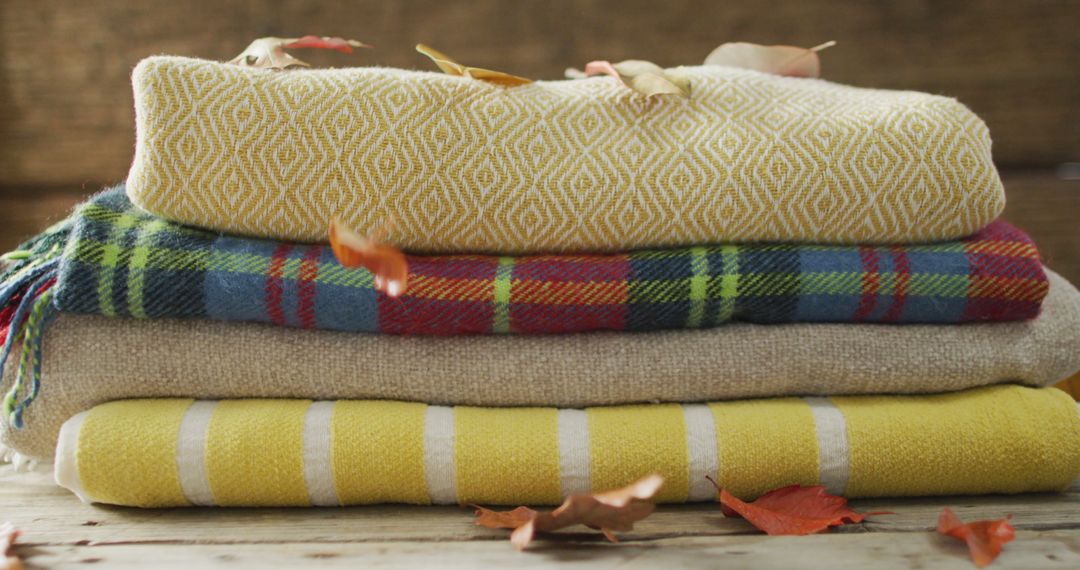 Image of folded blankets and autumn leaves on wooden background - Free Images, Stock Photos and Pictures on Pikwizard.com
