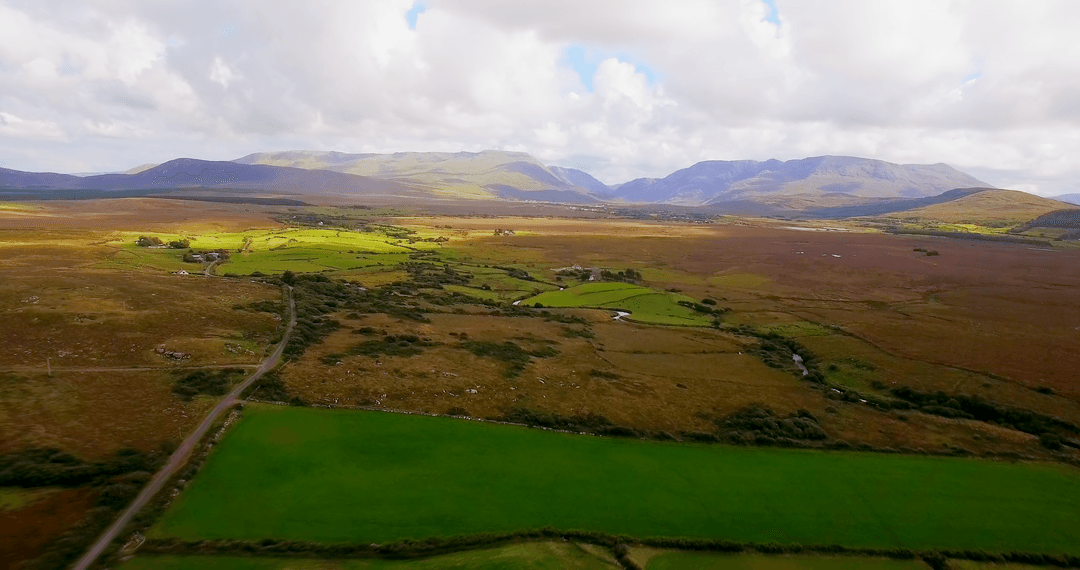 Transparent Green Fields and Mountains under Blue Sky