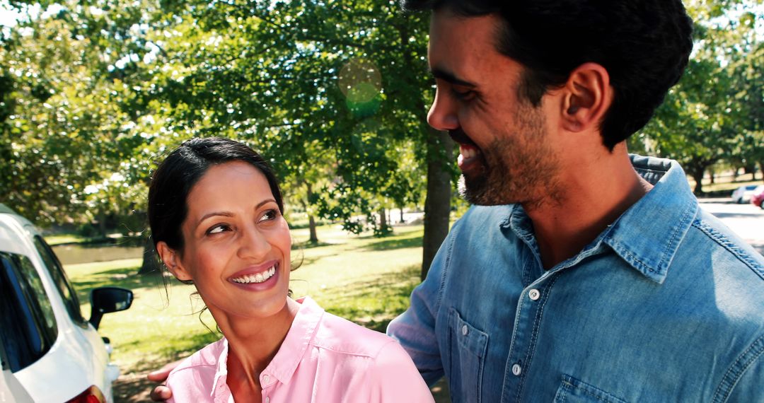 Smiling Couple Embracing in Sunlit Parkland