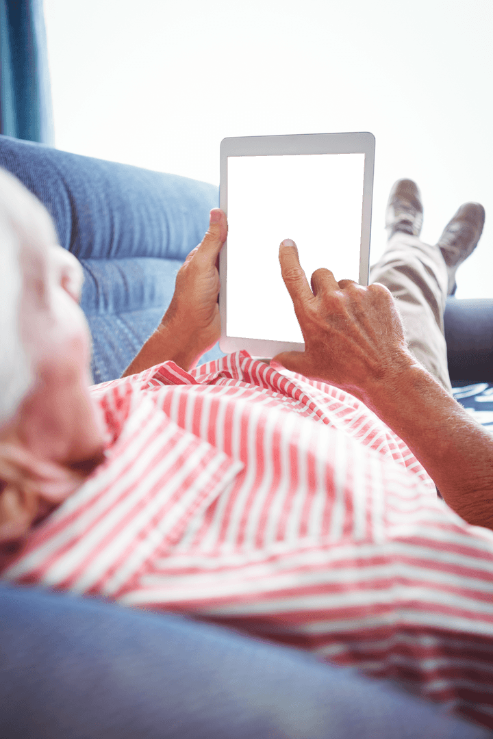 Elderly Man Using Tablet Interface Transparent Screen Relaxing on Sofa