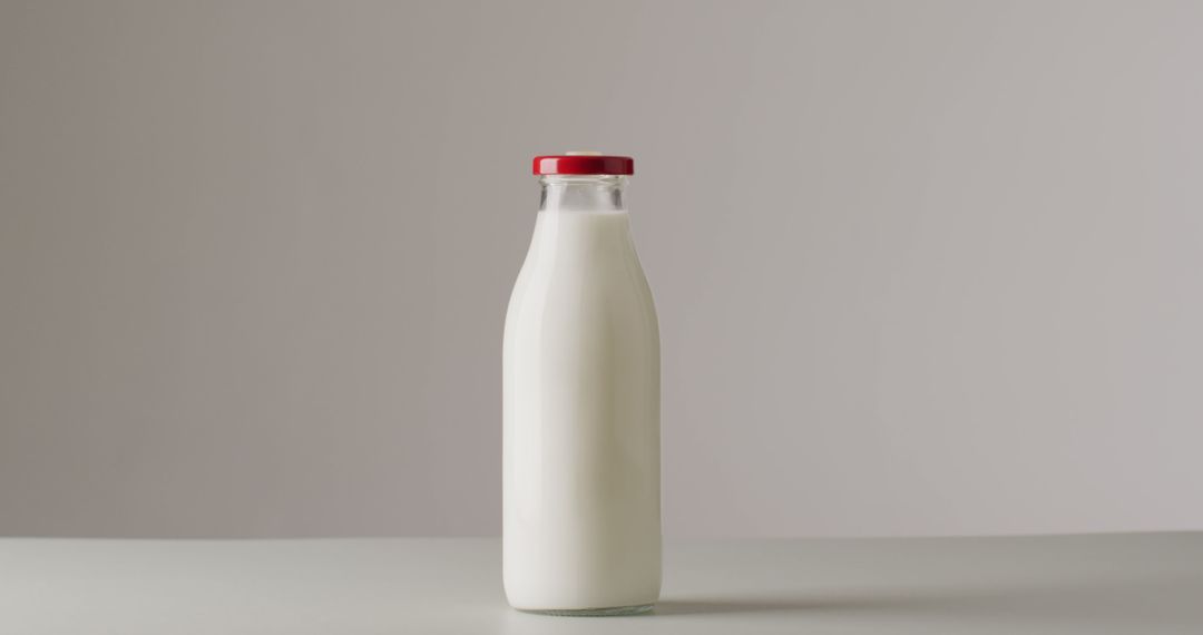 Glass Milk Bottle with Red Cap on Light Background - Free Images, Stock Photos and Pictures on Pikwizard.com